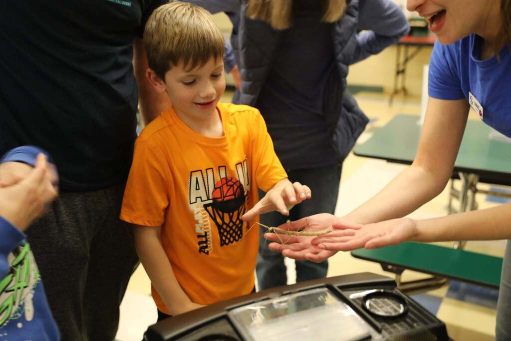 a student touching a walking stick
