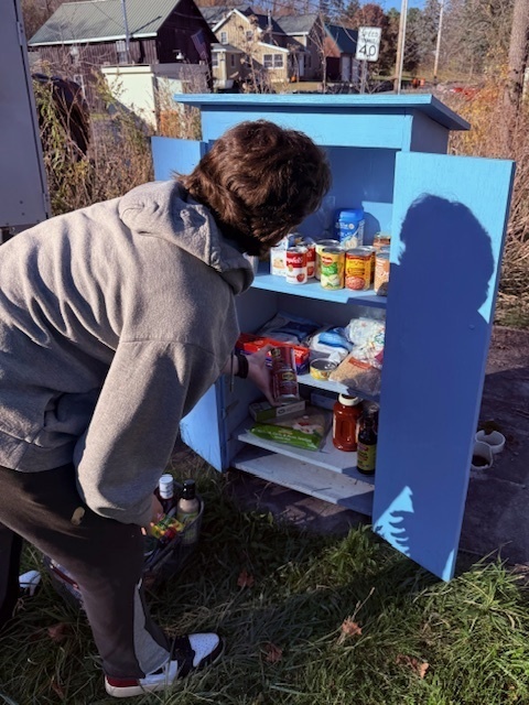 Student volunteering  by stocking shelves of food pantry