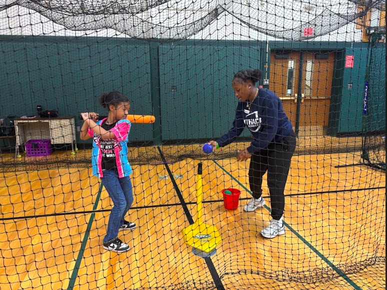 Student volunteering at softball clinic