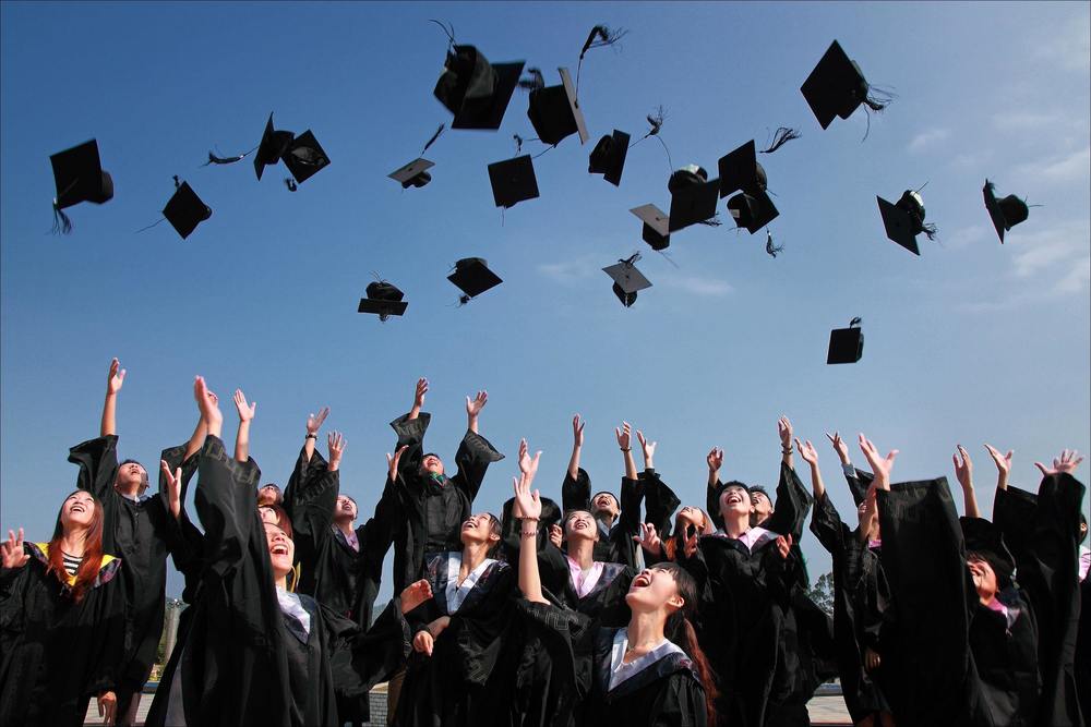graduation caps in air