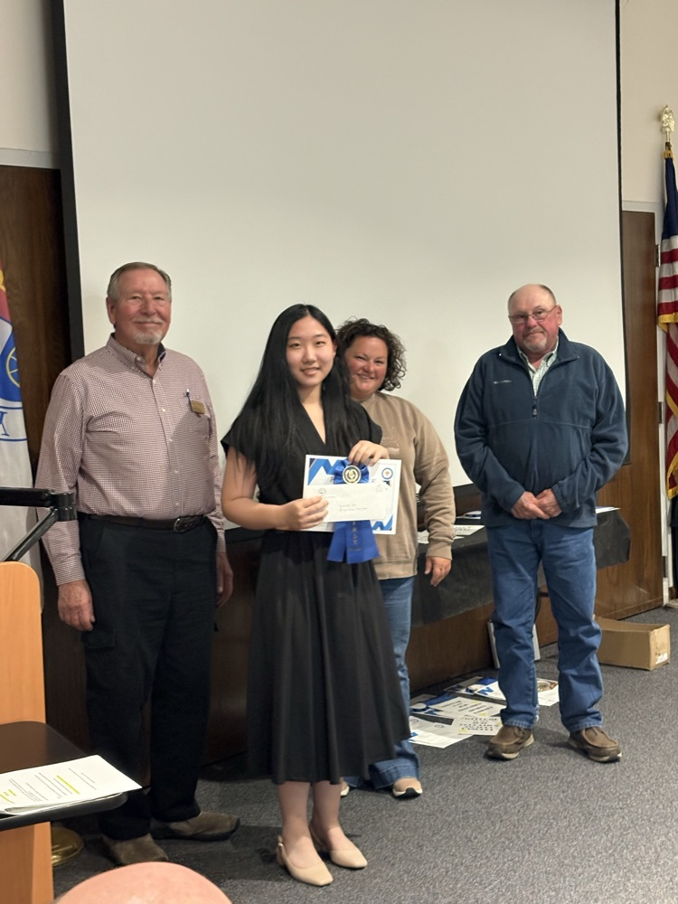 Yuanman being presented with her certificate by the board members