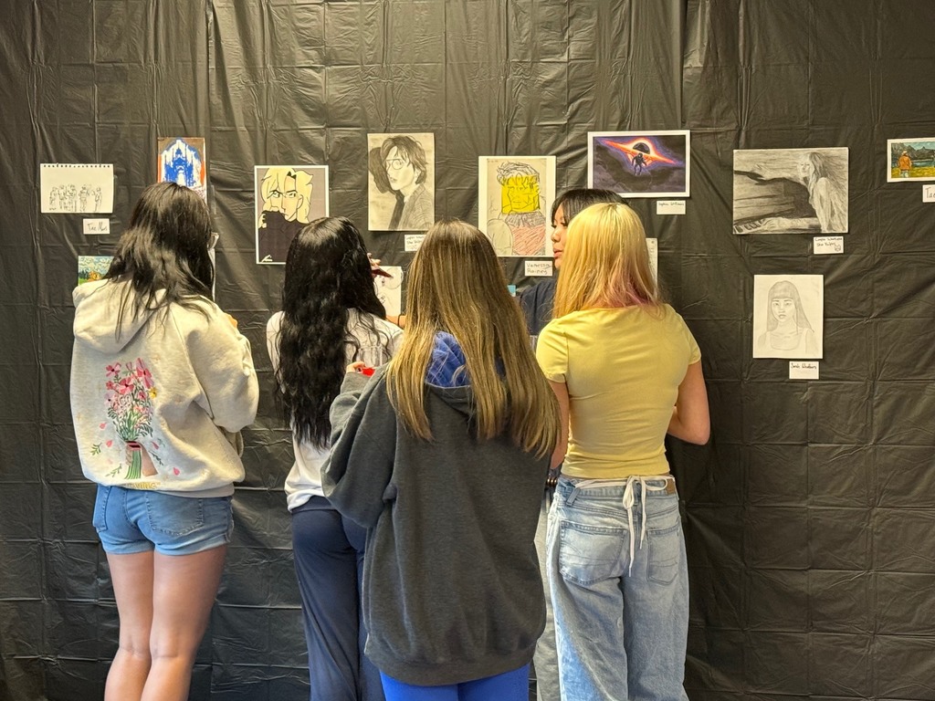 Students admiring the art work created by students participating in the art enrichment.