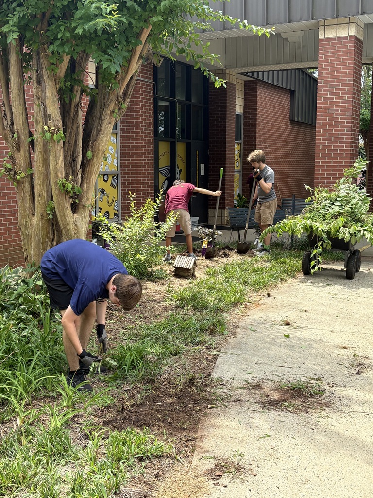 Jackson, Cruz, and Anthony weeding the flower bed