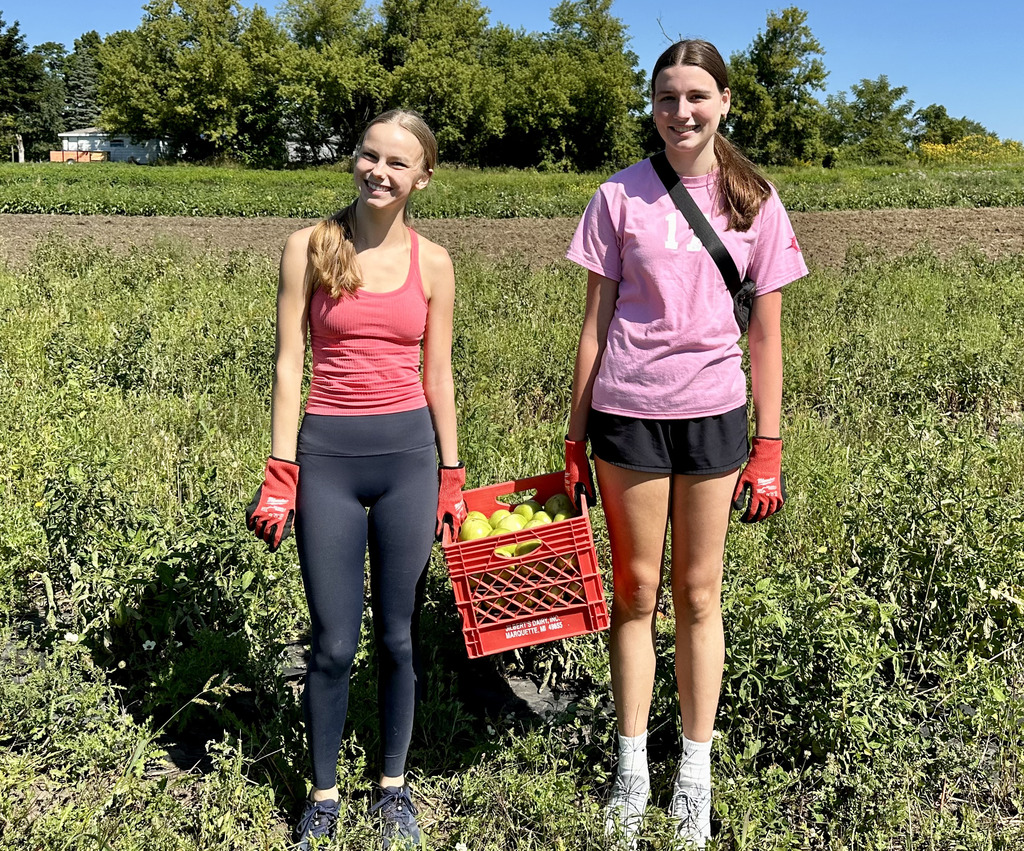 two students holding a red basket