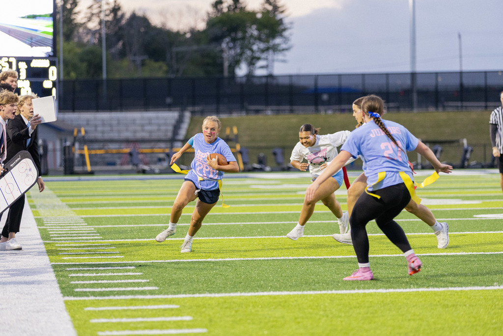 a picture of a girl carrying a football