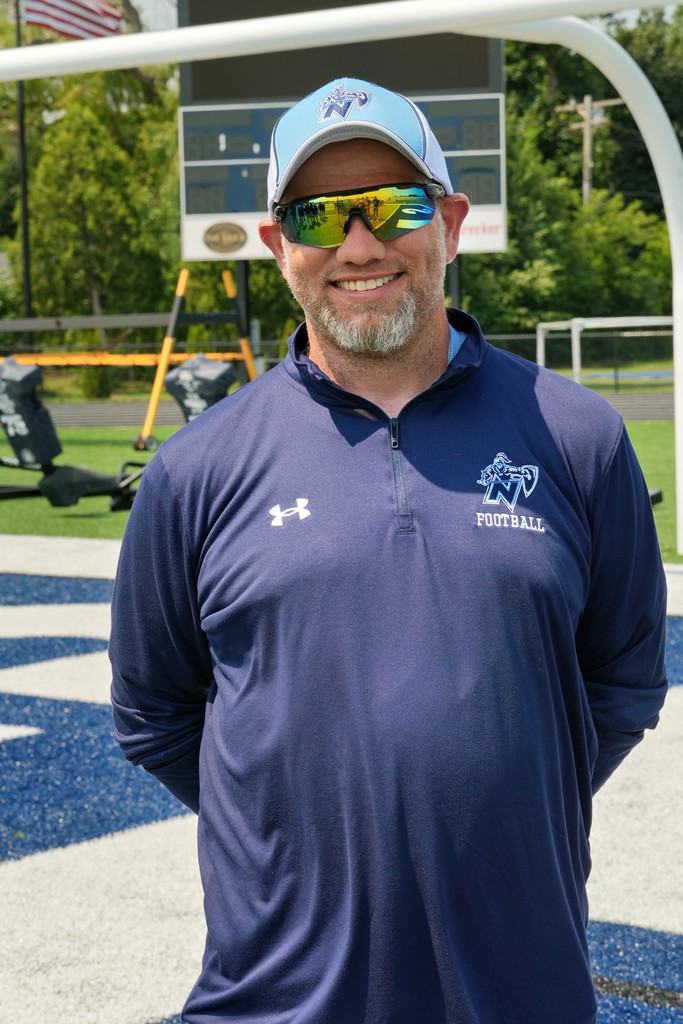 a football coach smiling for the camera
