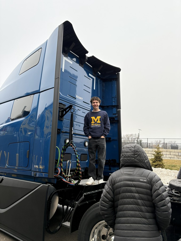 a student taking a picture on a semi cab