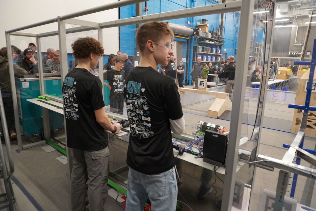 two students watching a robot