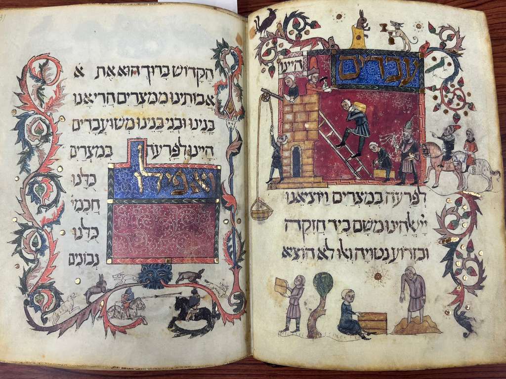 An open book with Hebrew text and illustrations. One page shows people climbing a tower while another depicts a building.