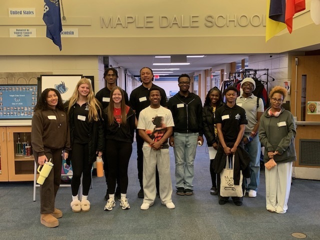 Group of students and faculty at Maple Dale School, standing together in front of a sign.