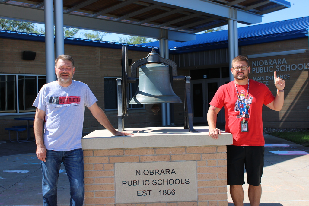In front of the school by the bell
