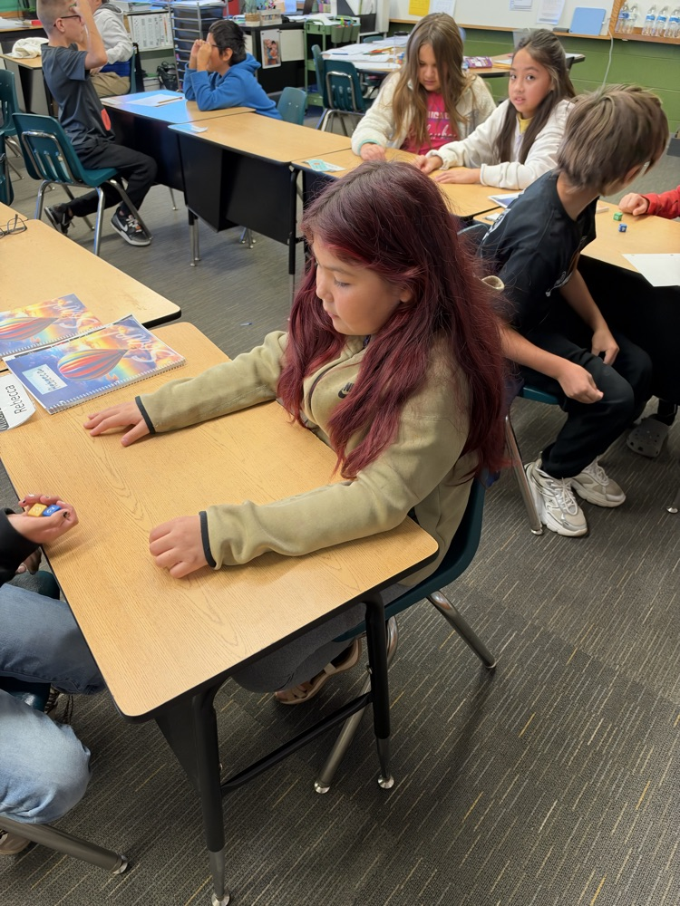 Third-grade students engage in an interactive game called Roll and Multiply to practice multiplication facts in a fun and engaging way while building fact fluency.