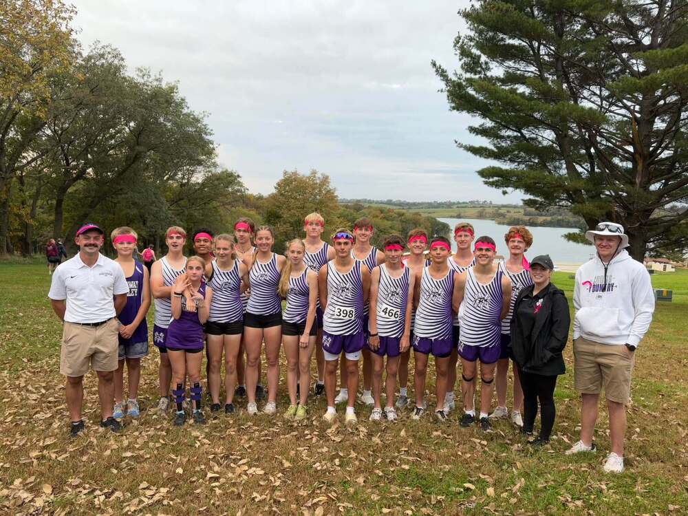 Nodaway Valley cross country runners and coaches pose together near a lake at the Pride of Iowa Conference meet.