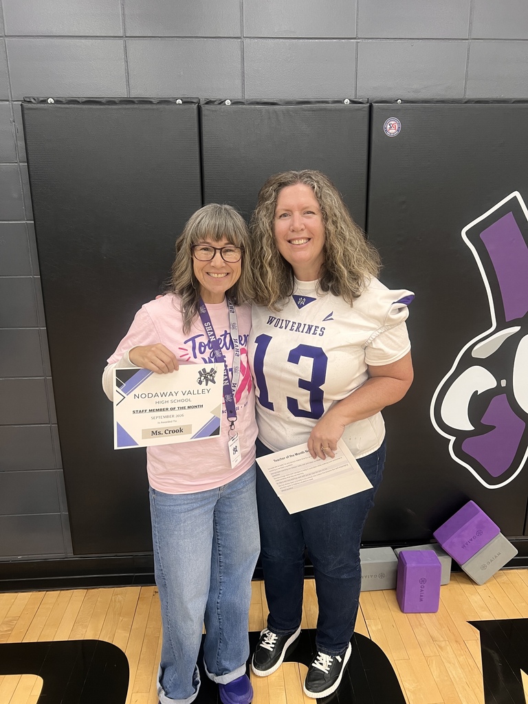 Two teachers holding their teachers of the month awards