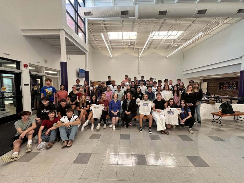 Students in school commons showing shirts that were sponsored for the event