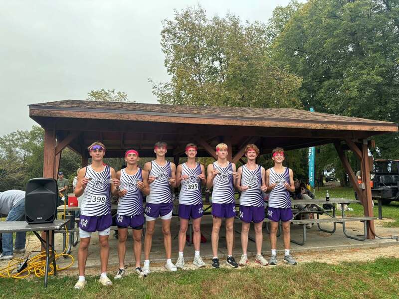 Seven Nodaway Valley boys cross country runners display their medals after the team’s third consecutive Pride of Iowa Conference championship.