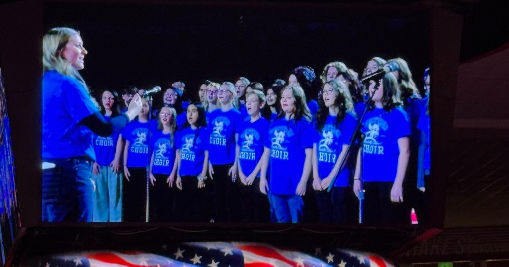 Photos of Whittier Choir singing at the OU Women's Basketball Game.