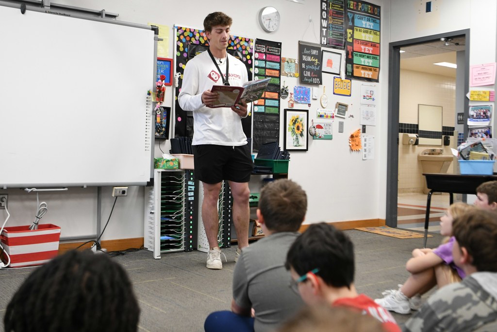 Various photos of Brendan Brock reading to kids.