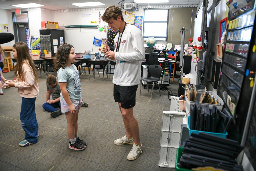 Various photos of Brendan Brock reading to kids.