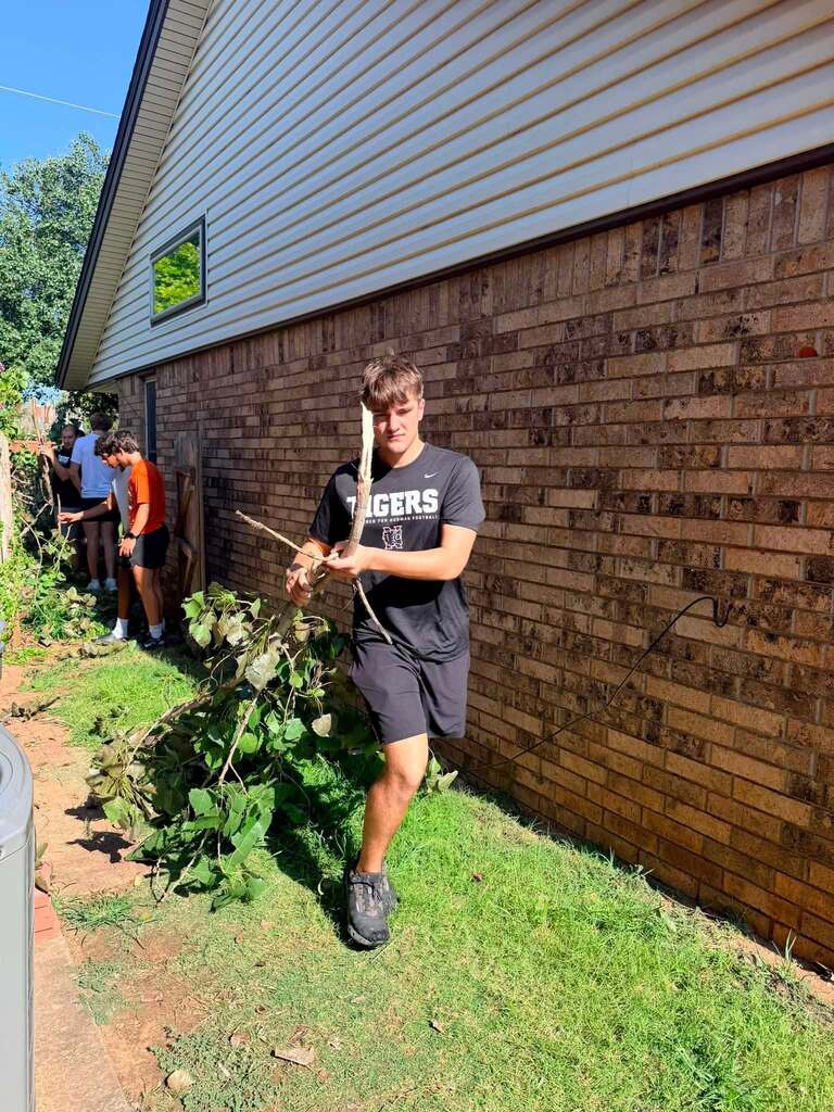 Various photos of Norman High football team helping clean up after storms.