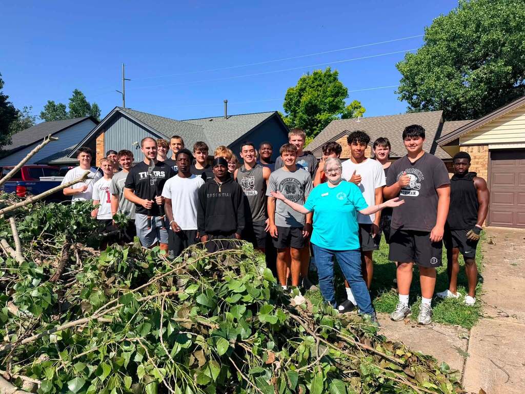 Various photos of Norman High football team helping clean up after storms.