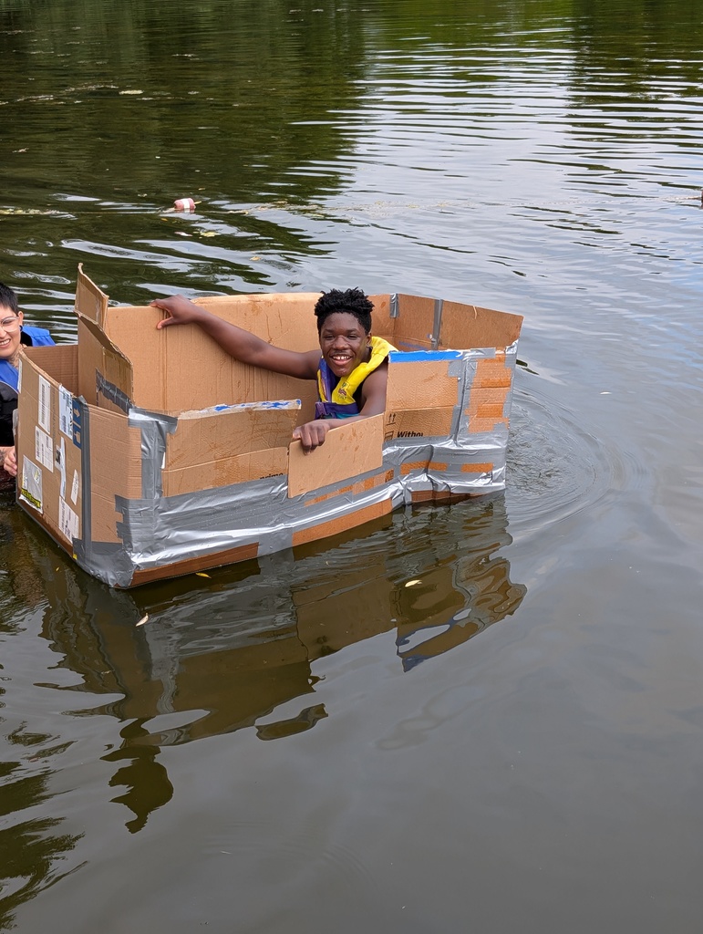 learner in a carboard boat in a pond