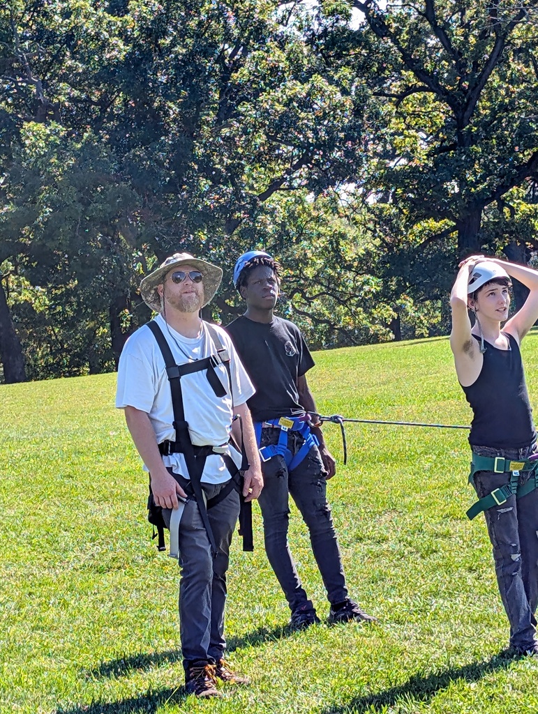 staff with two learners working the ropes for the high ropes course