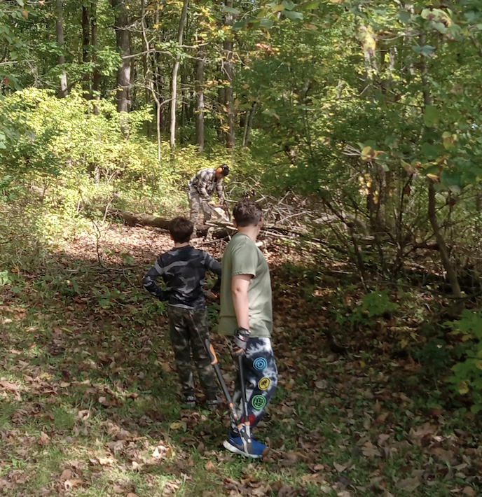 two learners helping staff with wood