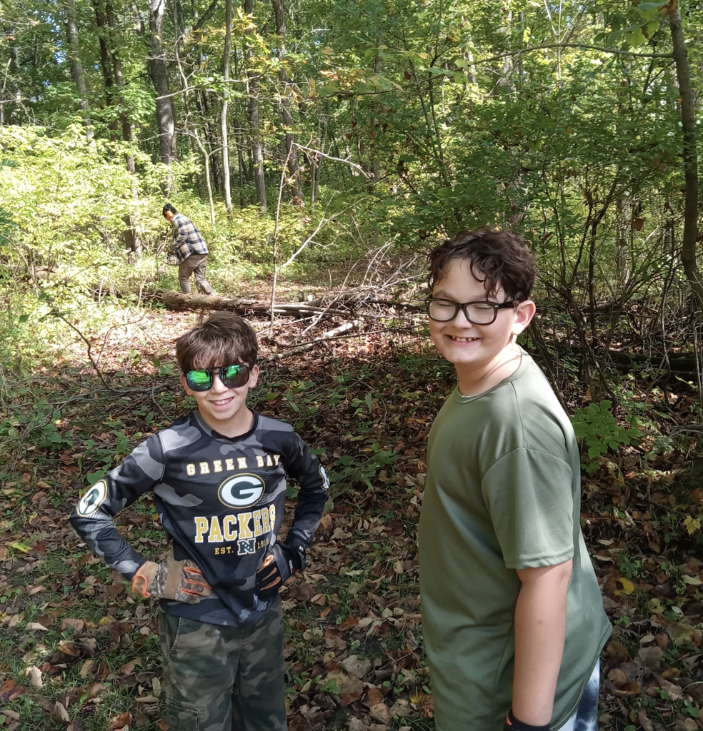 two learners clearing trails in the woods