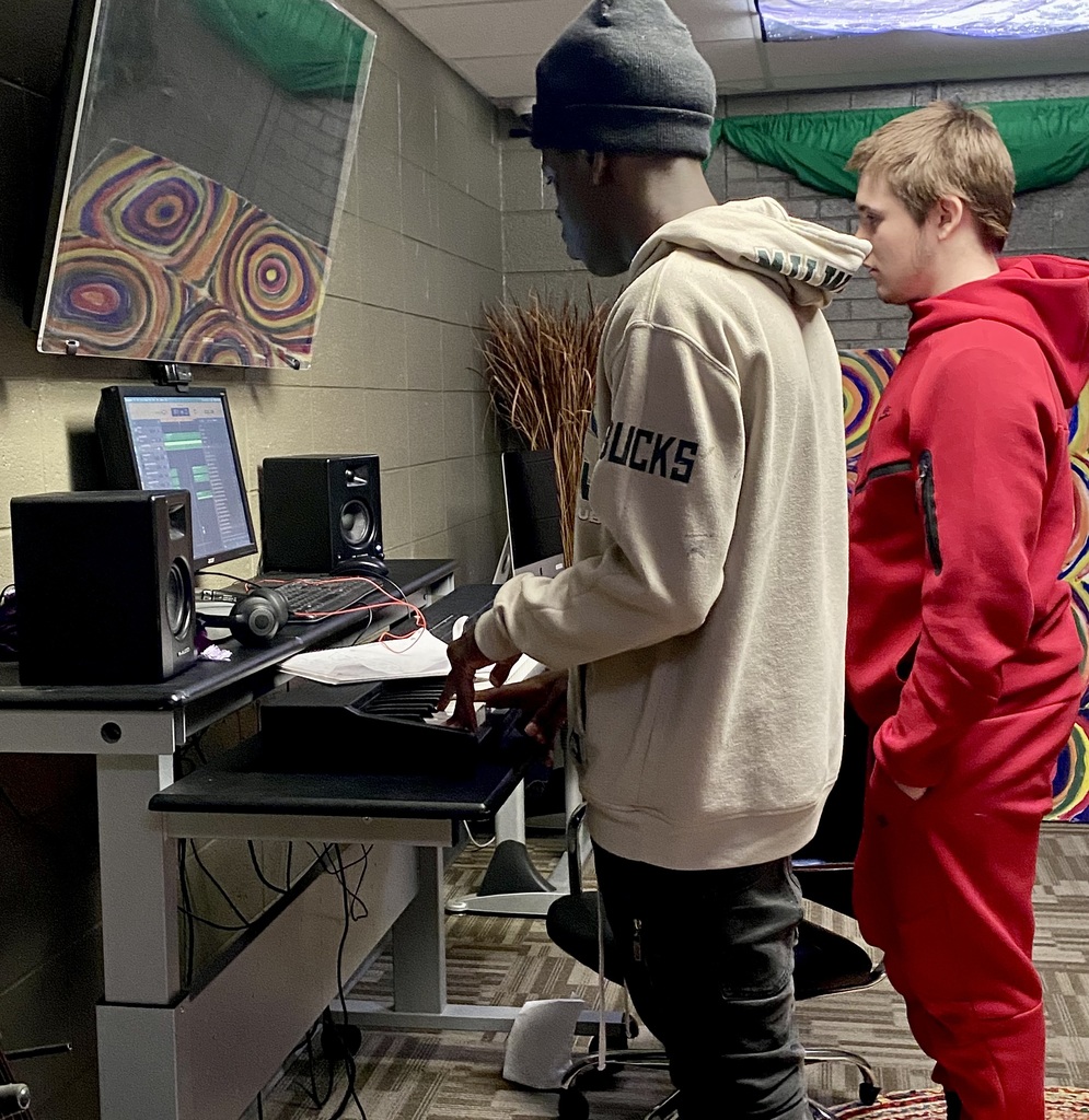 male learners mixing music on a sounfboard