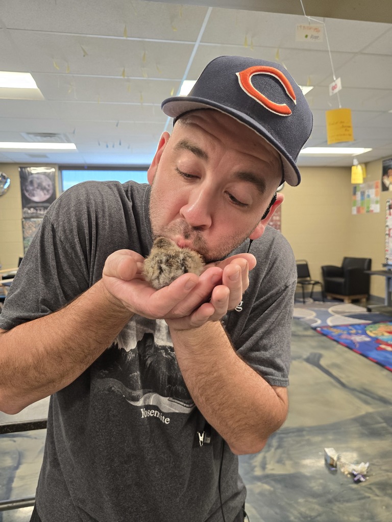 teacher holding a baby chick and kissing it