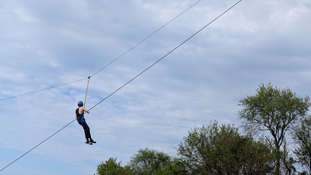 learner zip lining on the ropes course