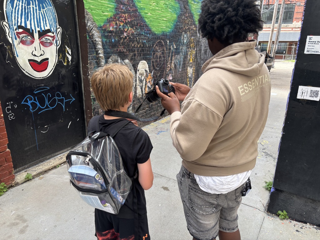 learners using the camera to capture pictures of wall art