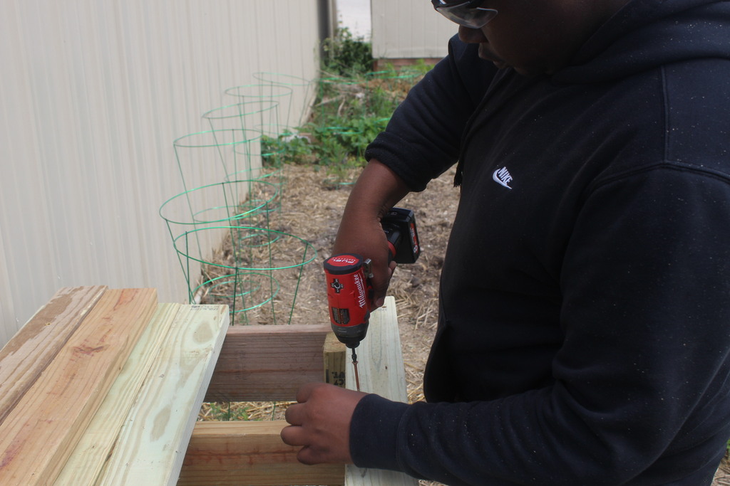 learner using a tool to screw in screws