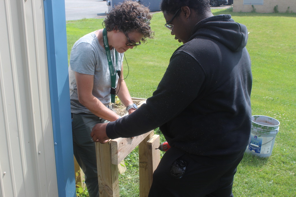 Learner and staff working together to build wooden structure