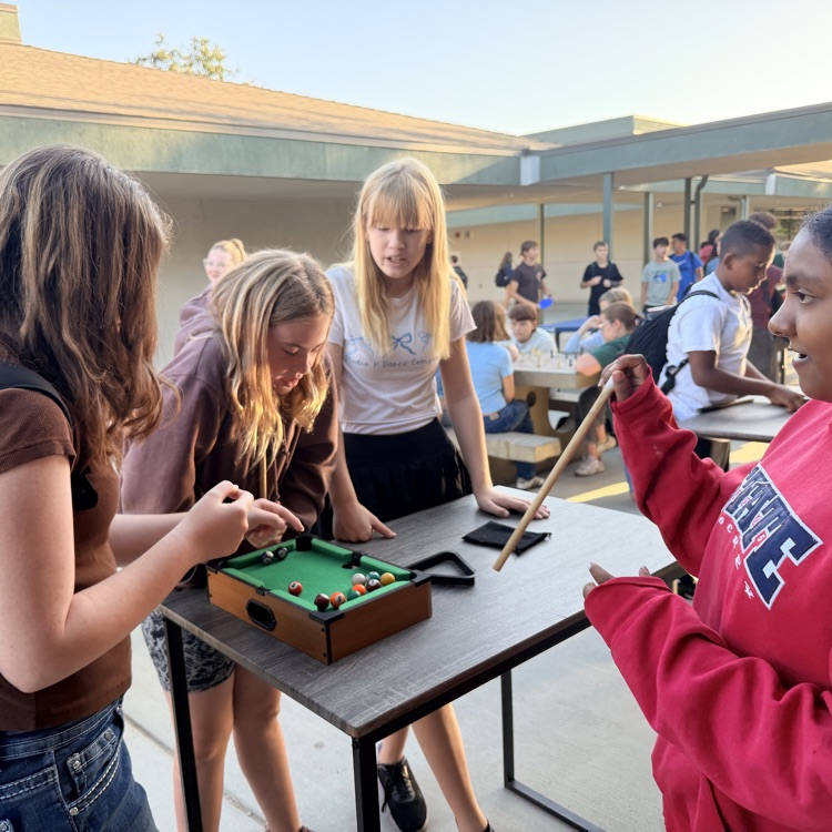 Students playing mini-pool table