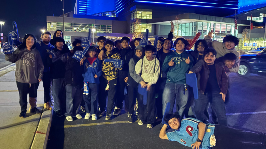 Group of students standing together in parking lot outside the Wells Fargo Center