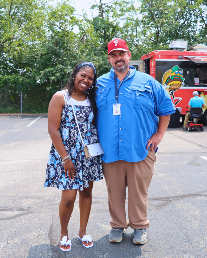 Two NASD staff members pose for photo in front of the food truck.