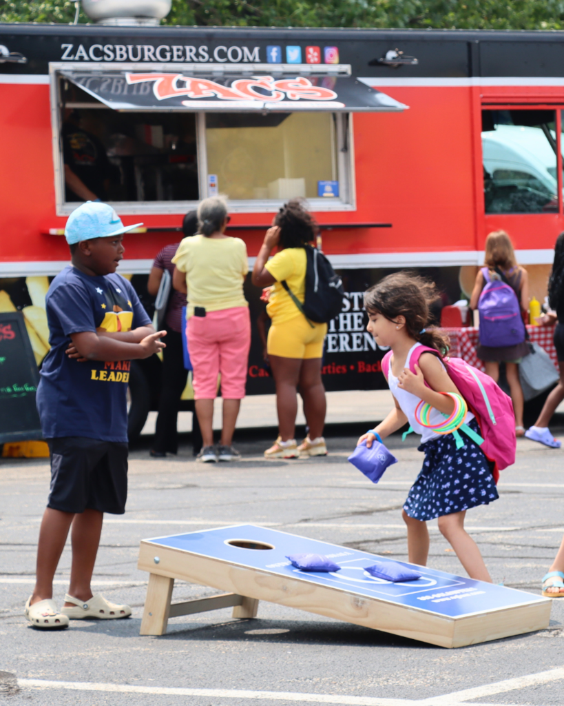 Two young students playing corn hole at the Back to School Bash.