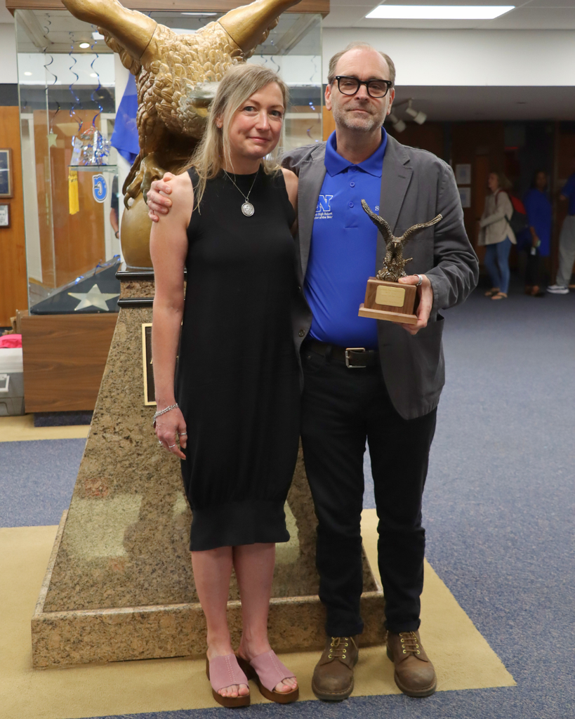 Mr. Stansbery and his wife pose for photo in high school lobby.