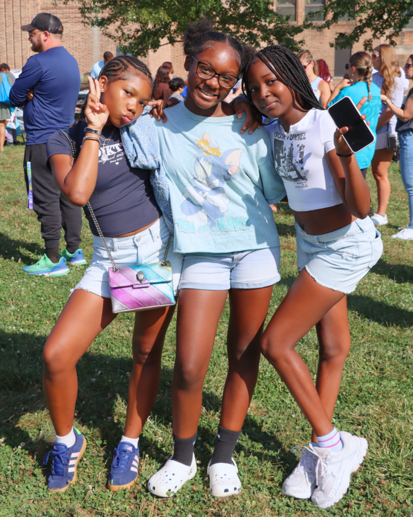 Three students pose for photo at back to school event.