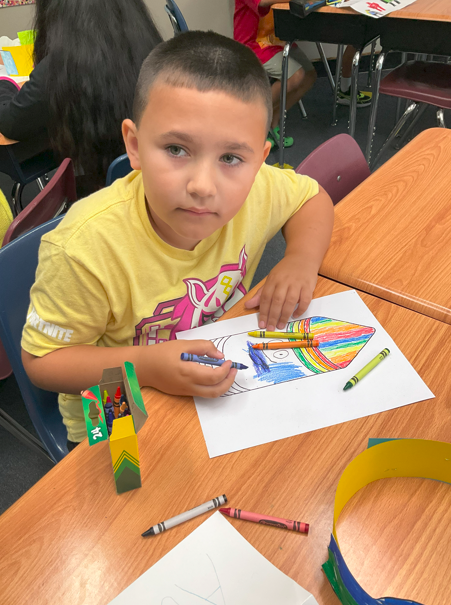A student coloring on the first day of school. 