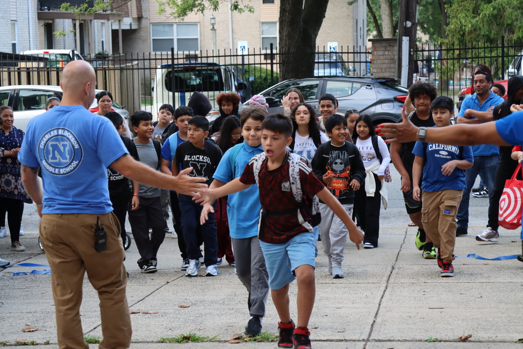 Crowds of students entering Blockson Middle School and giving high fives to the assistant principal More information in caption