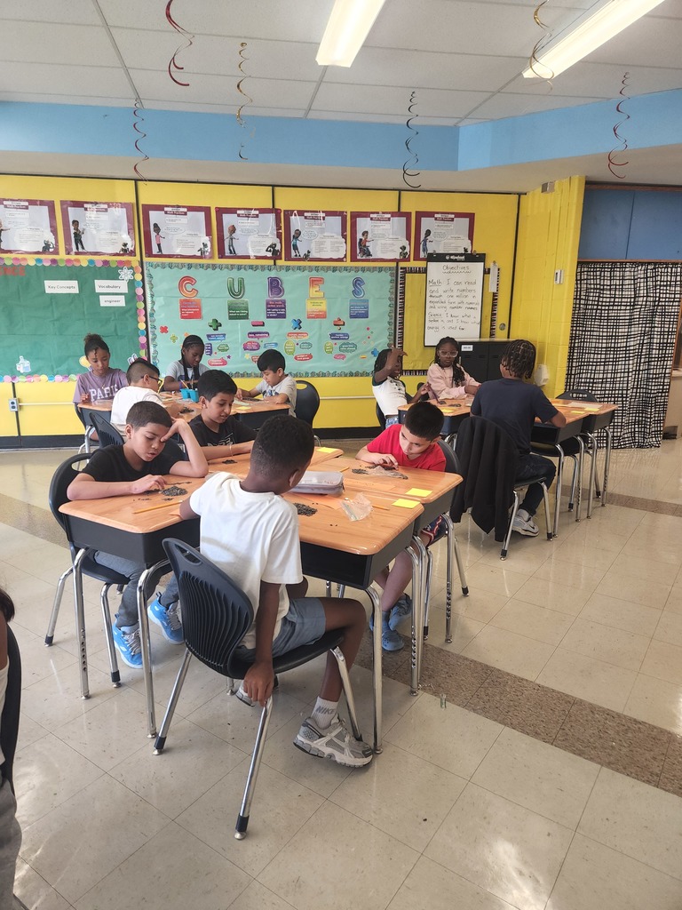 A group of students using watermelon seeds to work on place value. 