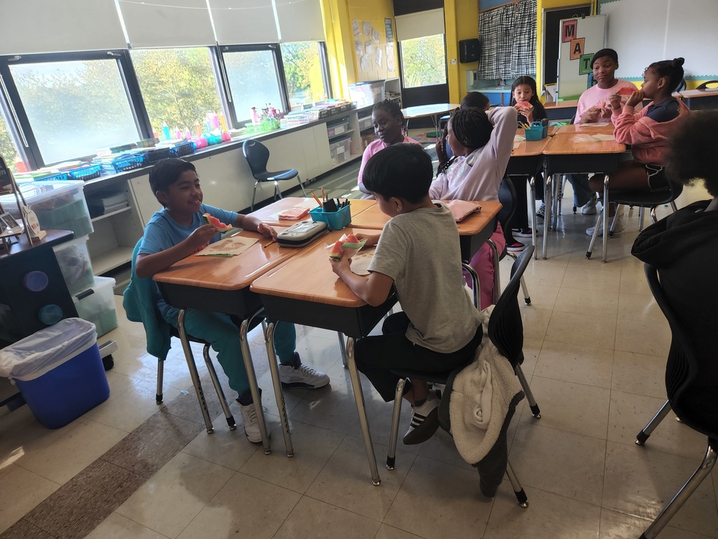 A group of students eating watermelon. 
