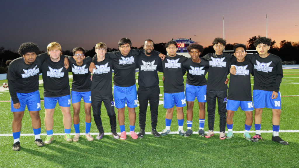 Group of boys soccer players and coach pose for photo on filed