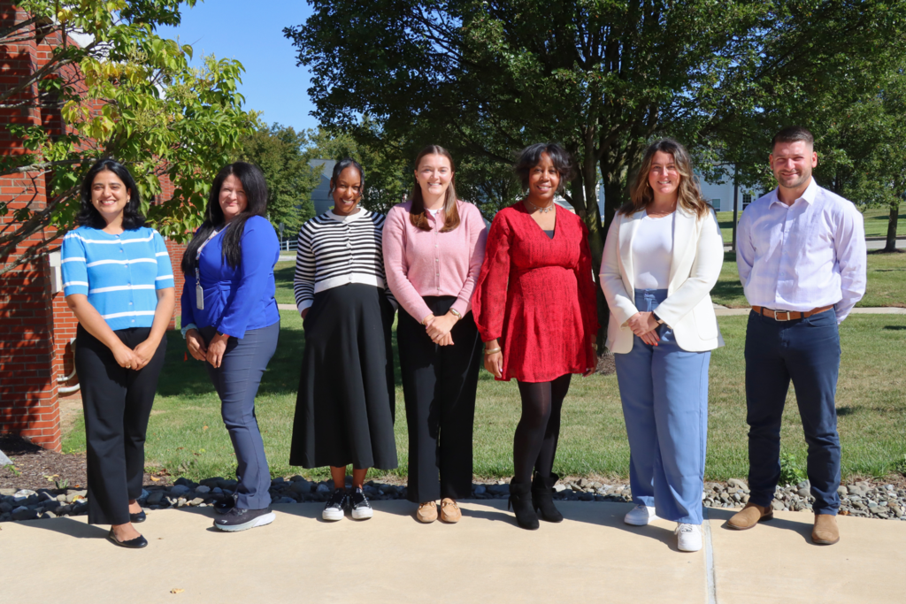 HR Team poses for group photo outside. 