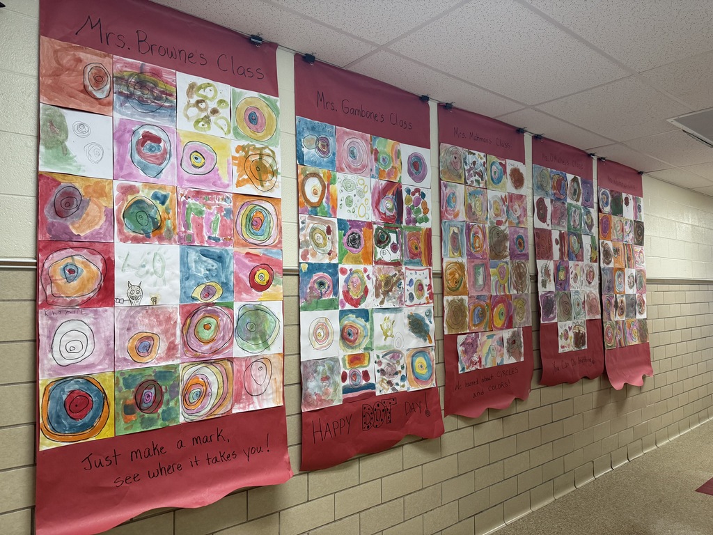 Kindergarten's Dot Day paintings on display in the hall.