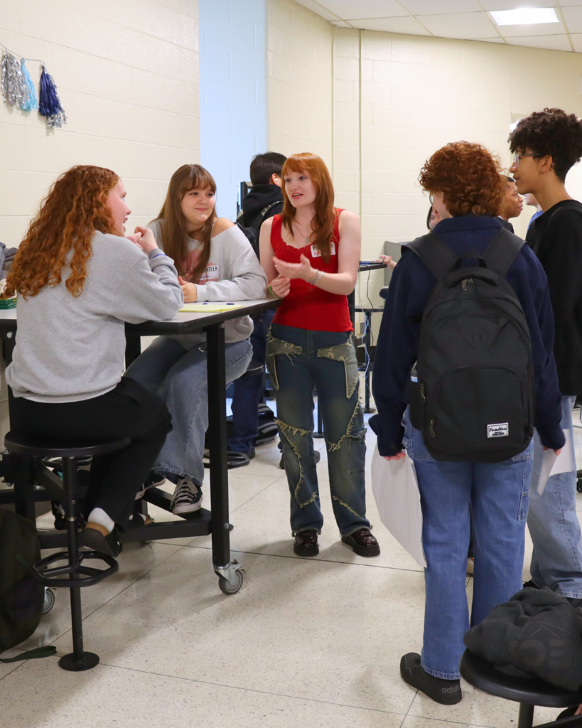 Upperclassmen speaking to 9th graders in the cafeteria about their club.