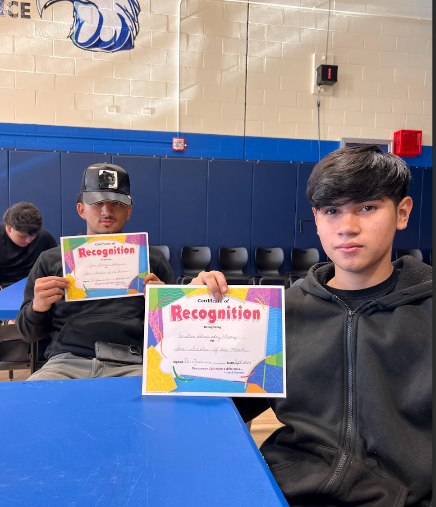 Two male students pose with their star student portraits.